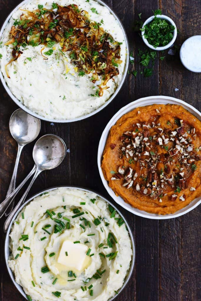 Overhead of three bowls of mashed potatoes