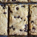 Overhead of chocolate chip cookie bar with bite taken out on a dark background