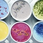 Overhead of naturally colored lattes in white mugs
