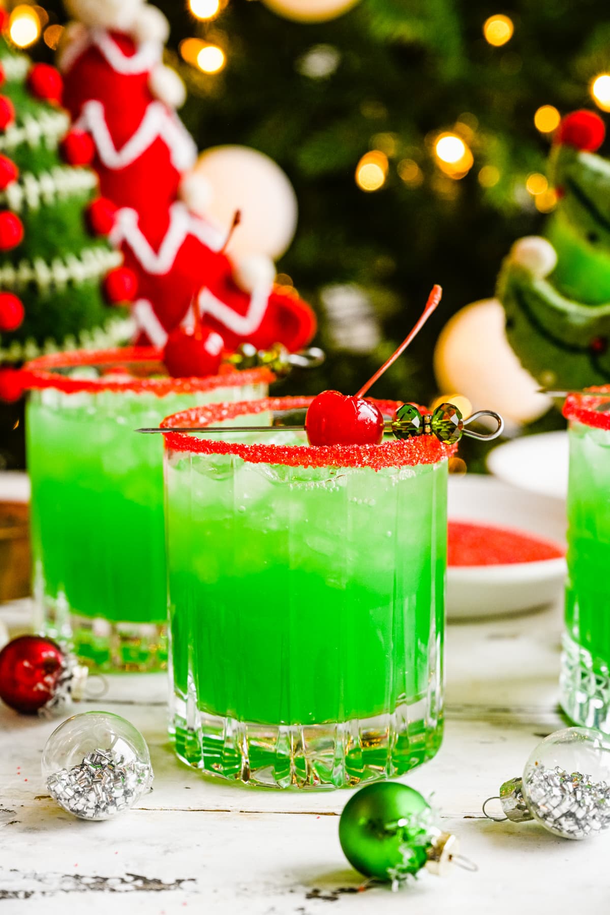 Close view of the finished grinch cocktails in front of tree.