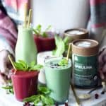 Holding a tray of holiday smoothies in glass jars