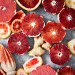 Overhead of sliced blood oranges, ginger and orange peels