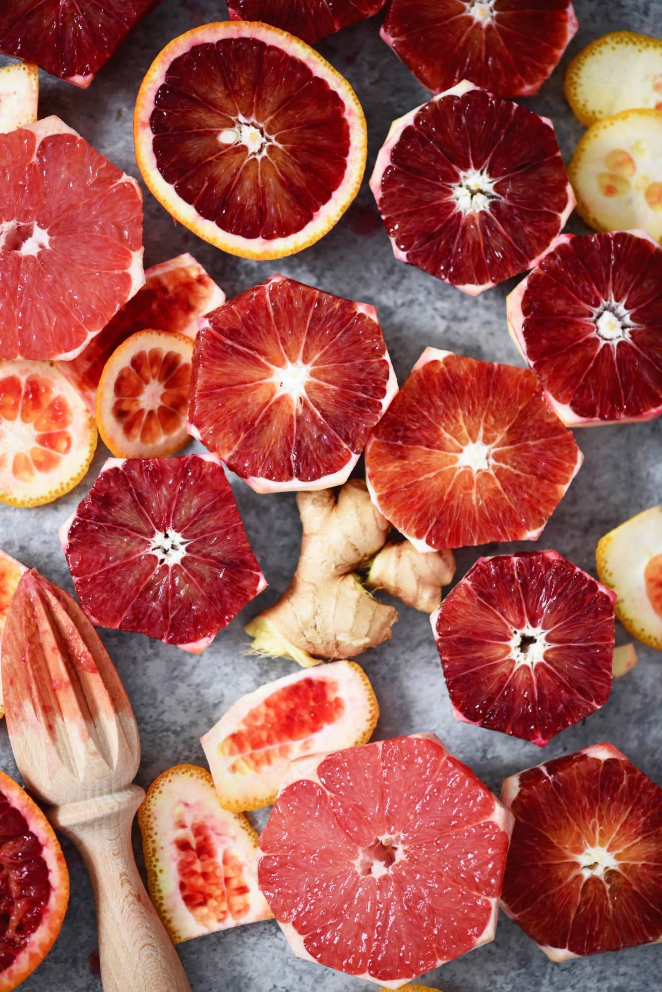 Overhead of sliced blood oranges, ginger and orange peels