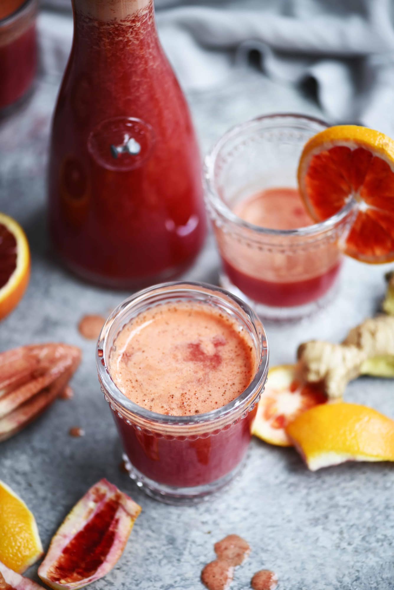 Side view of blood orange ginger juice in small glasses