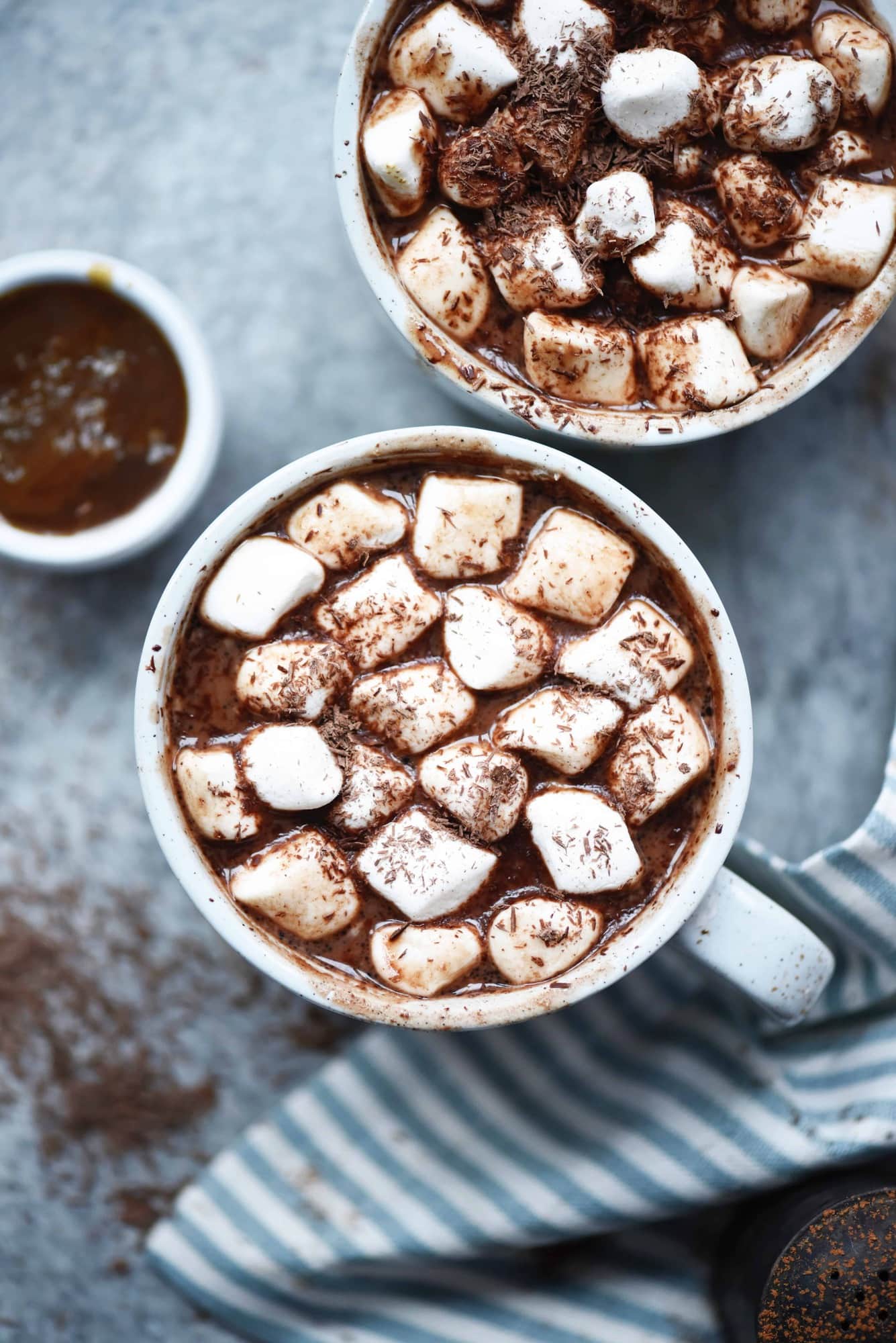 Overhead of salted caramel maca hot cocoa with vegan marshmallows with shaved dark chocolate