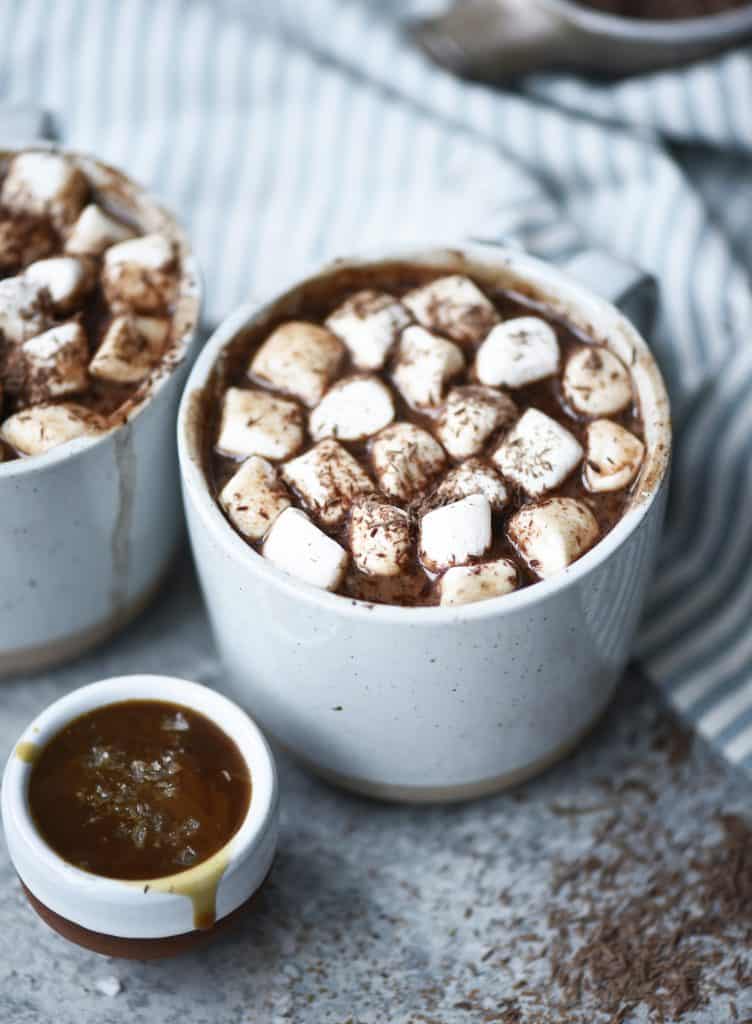 Side view of salted caramel maca hot cocoa with vegan marshmallows with shaved dark chocolate