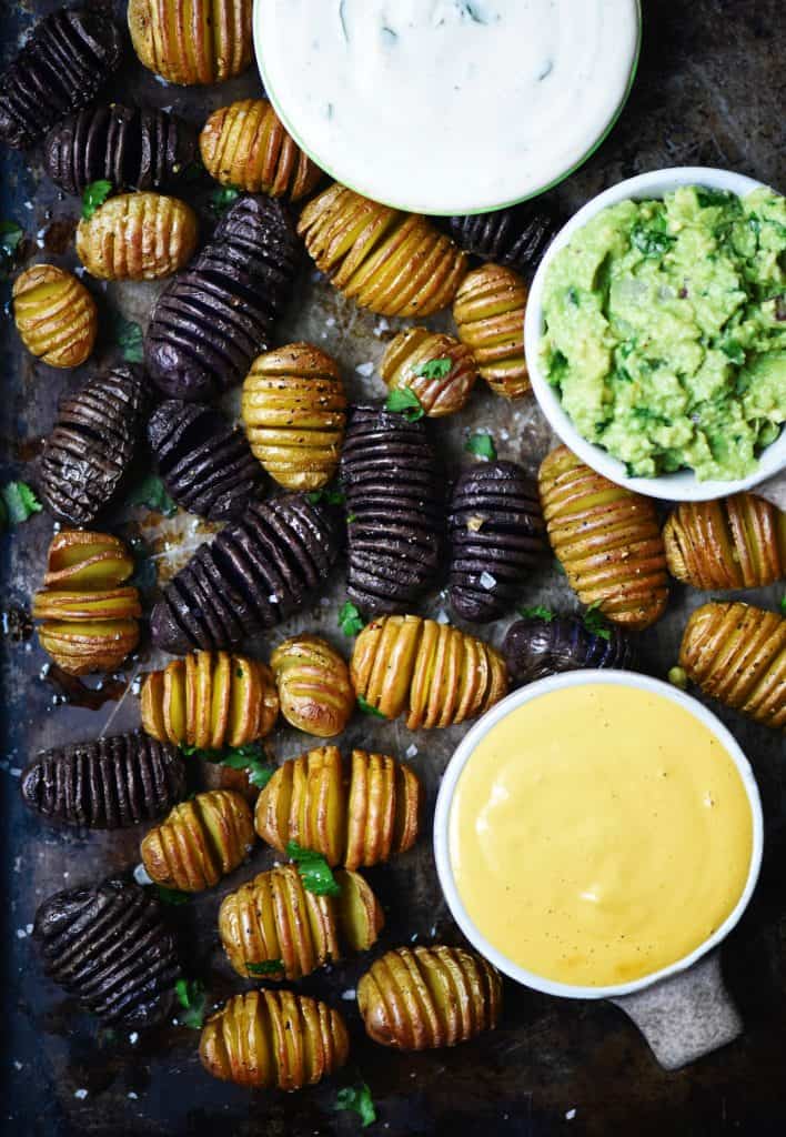 Overhead of mini hasselback potatoes with vegan queso dip