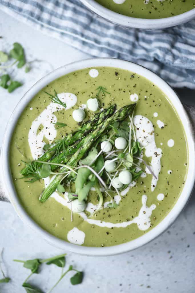 Overhead of asparagus soup with asparagus and peas