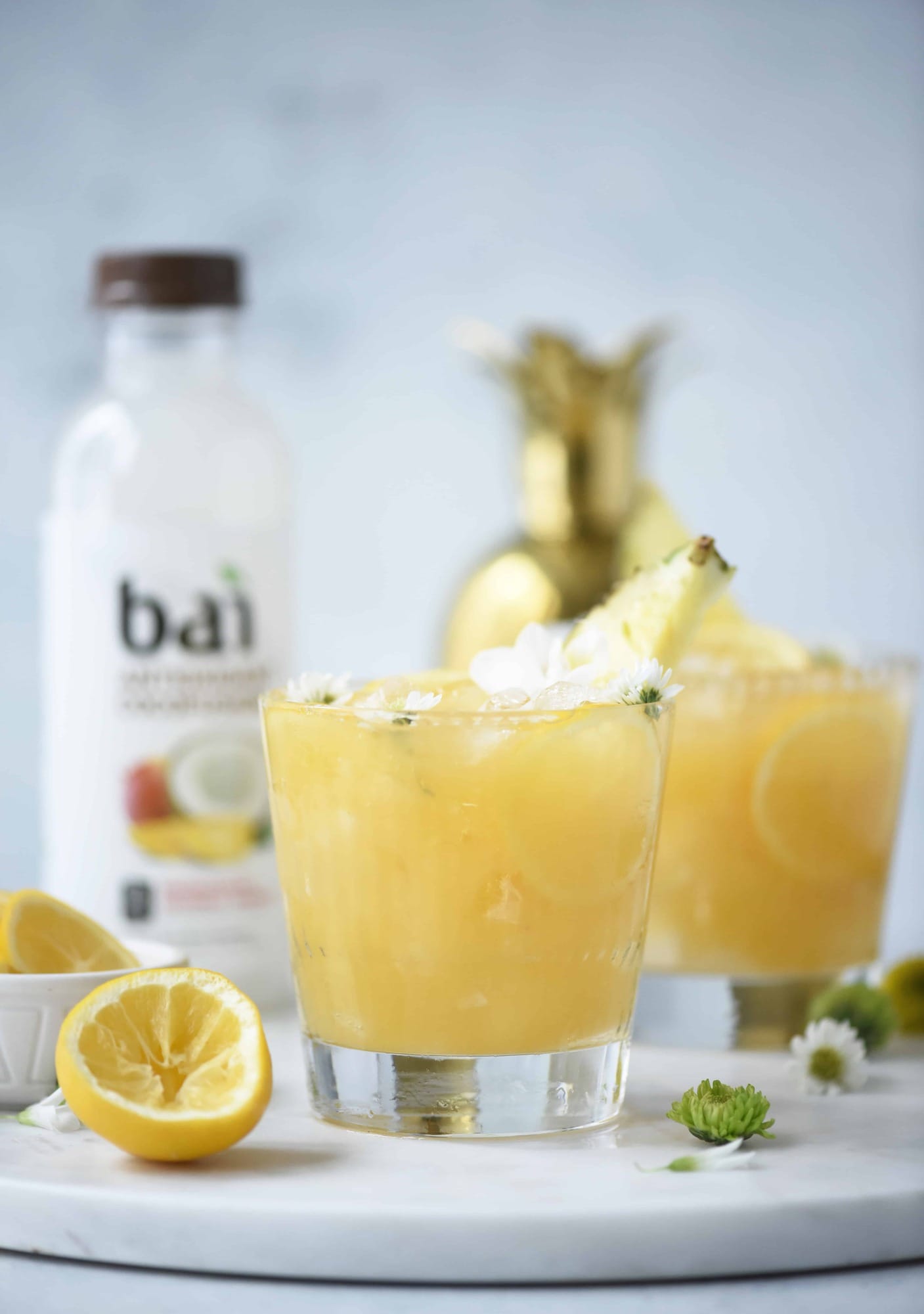 Side view of mango coconut pineapple rum punch on a white background