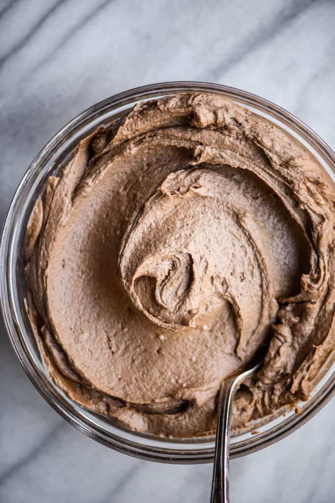Large glass bowl with vegan chocolate buttercream frosting