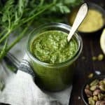 Side view of carrot top pesto in a glass jar