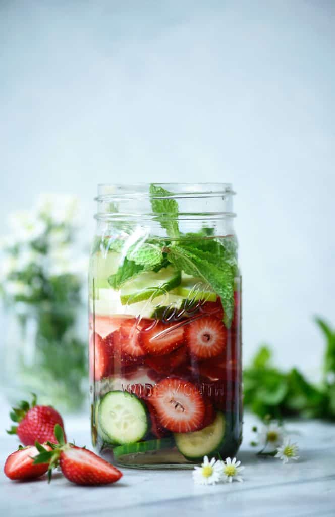 Large glass jar of strawberry cucumber mint infused water