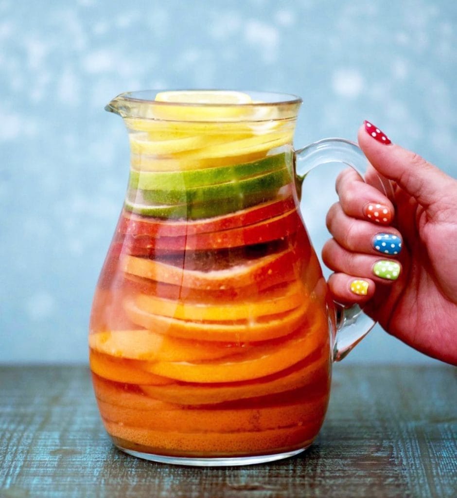 Rainbow citrus infused water with blue background