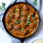 Overhead of vegan meatballs in sauce in a cast iron skillet