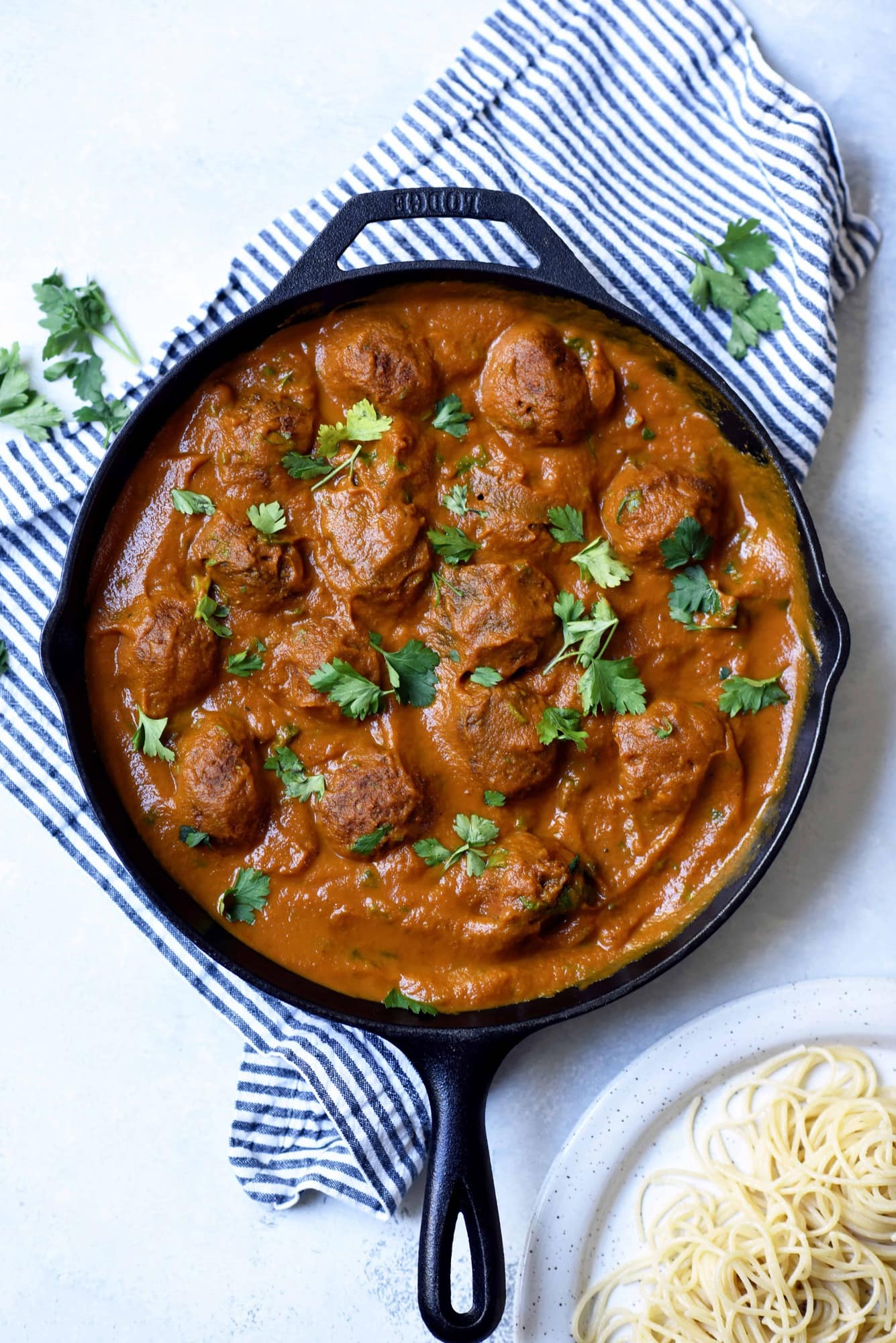 Overhead of vegan juice pulp meatballs in tomato sauce in a cast iron skillet