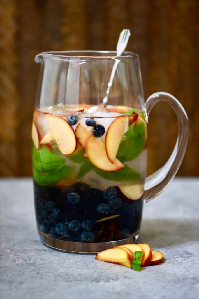 Large pitcher of peach, blueberry and basil infused water