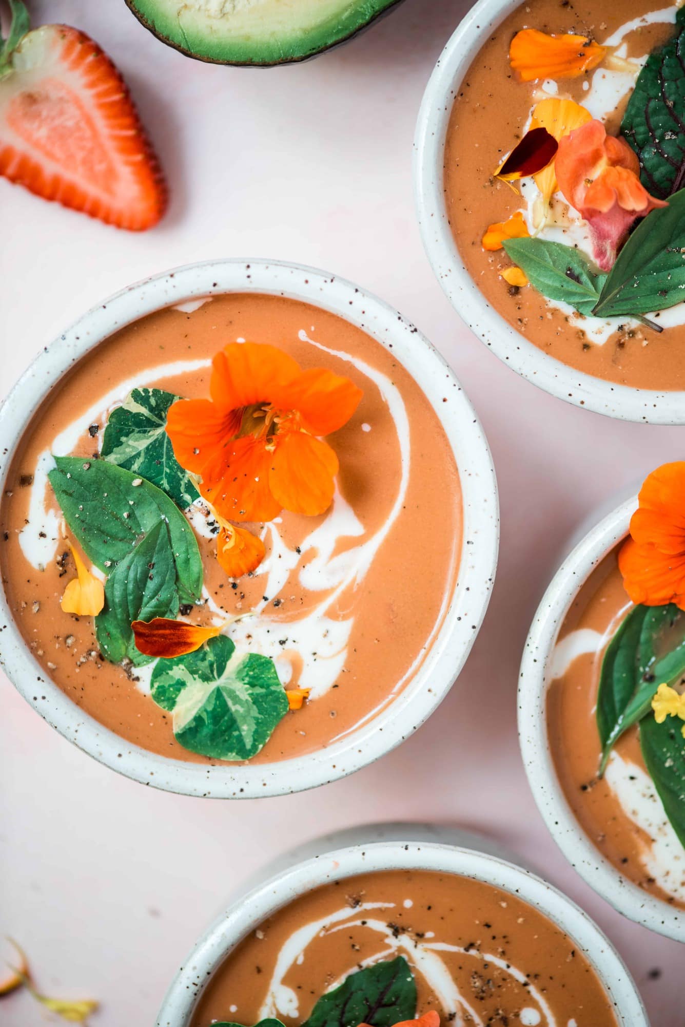 Close up Overhead of 4 bowls of strawberry watermelon gazpacho on a pink background