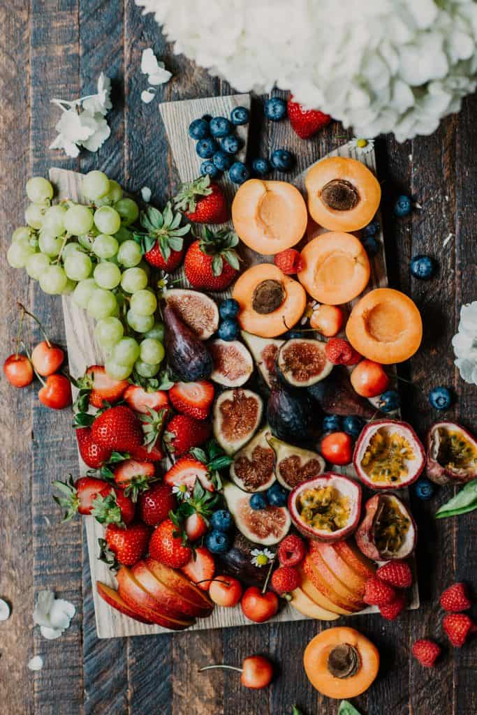 Fresh summer fruit on a wood cutting board and rustic, antique background