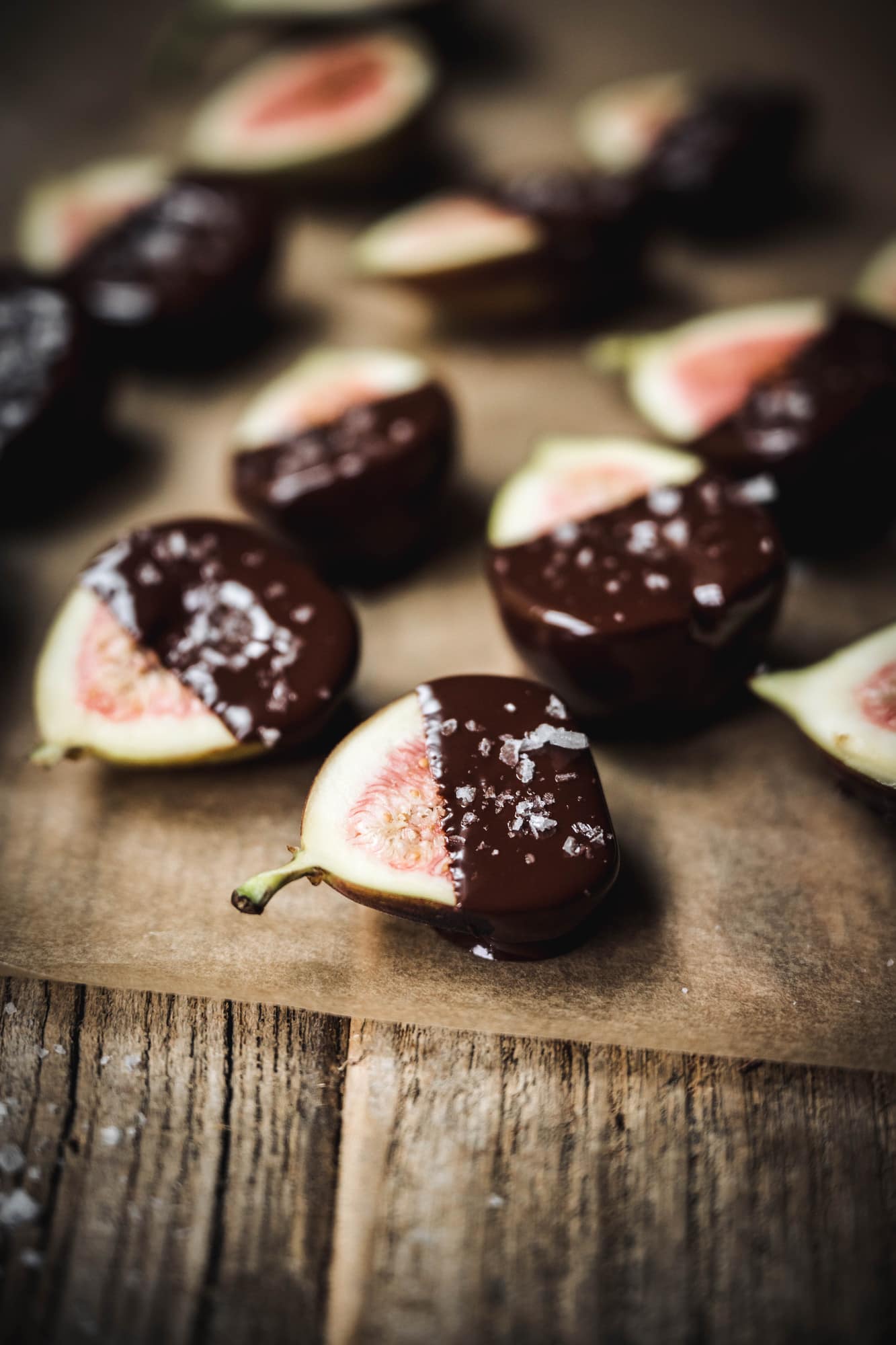 Side view of chocolate dipped figs with flaky sea salt