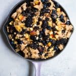 Overhead of blueberry nectarine bread pudding in a light purple cast iron skillet