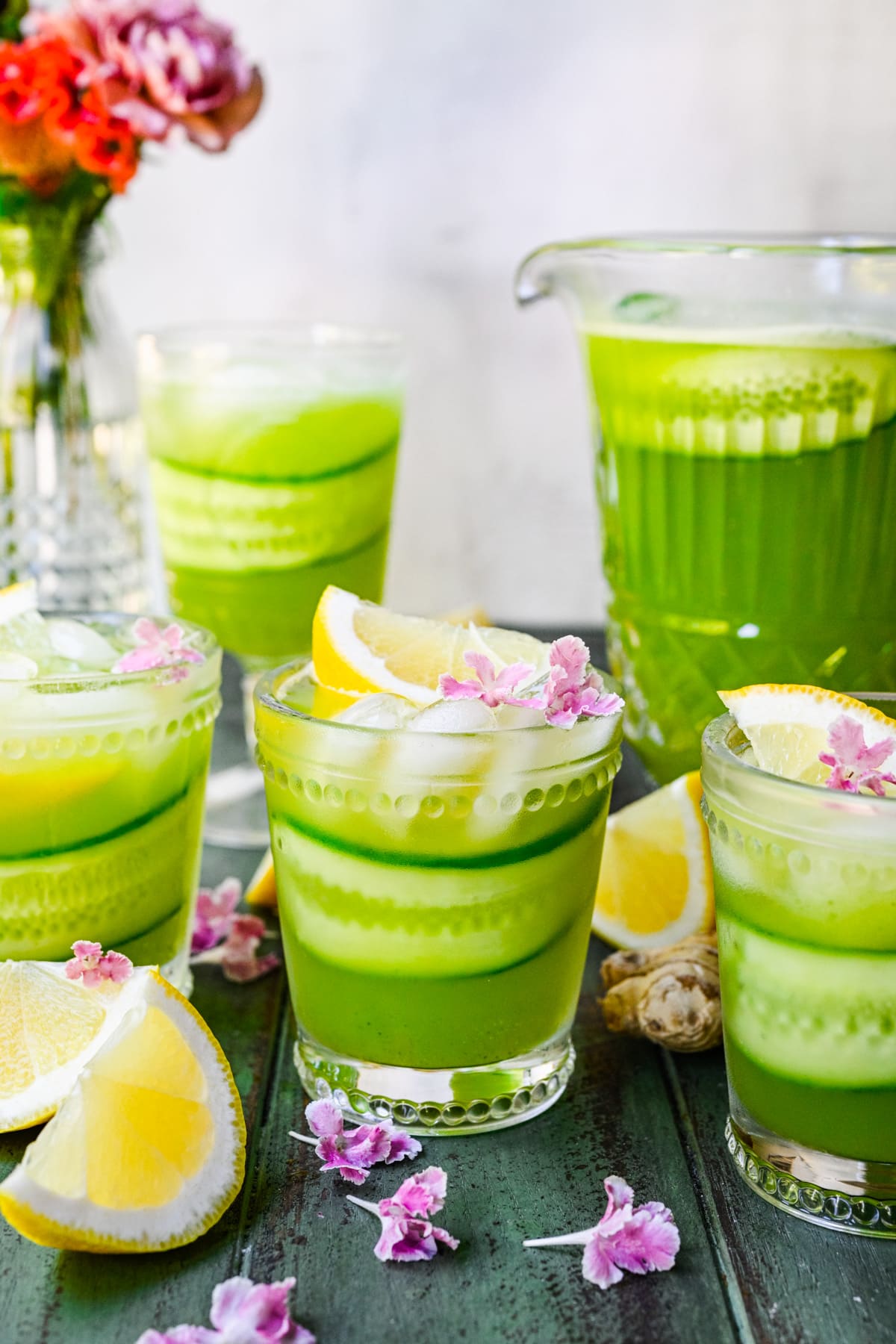 Front view of several glassed of green-colored lemonade.