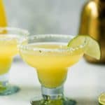 Pineapple jalapeno margarita garnished with lime on a white background