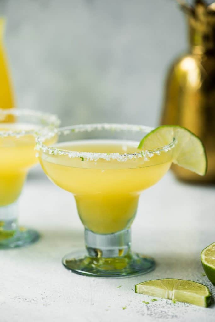 Pineapple jalapeno margarita garnished with lime on a white background