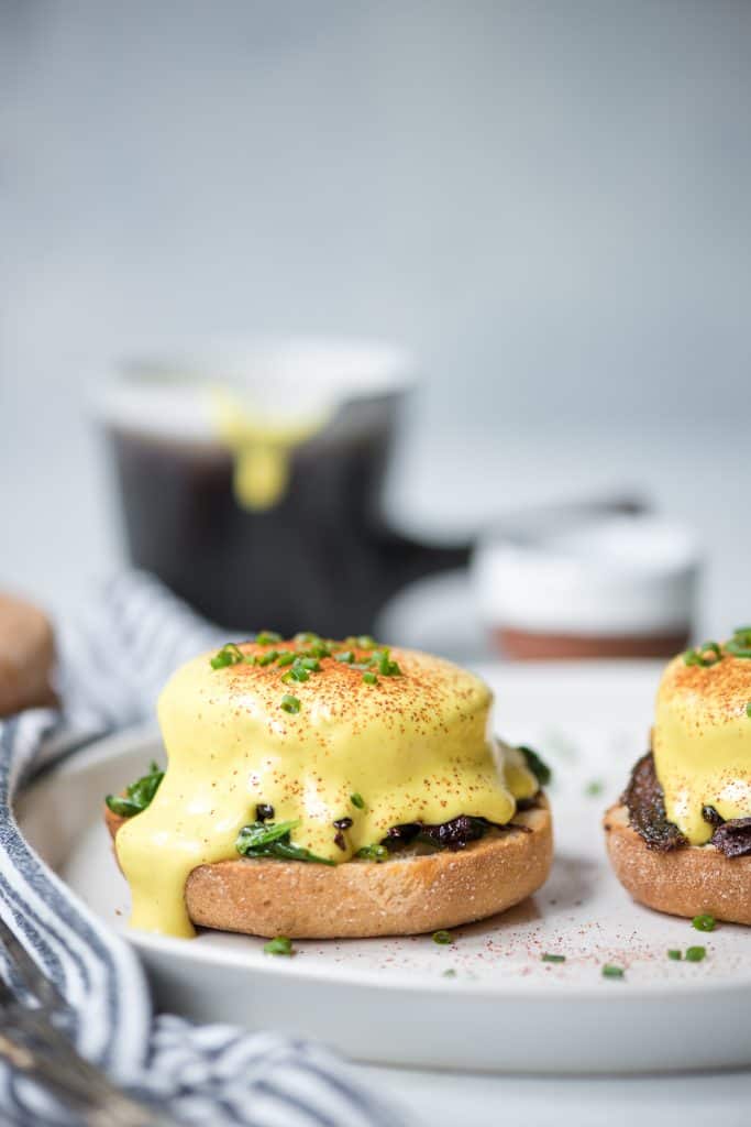 Side view of vegan polenta eggs benedict on a white plate
