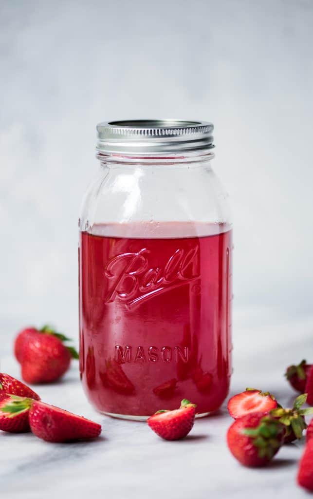 Ball jar of homemade strawberry infused vodka