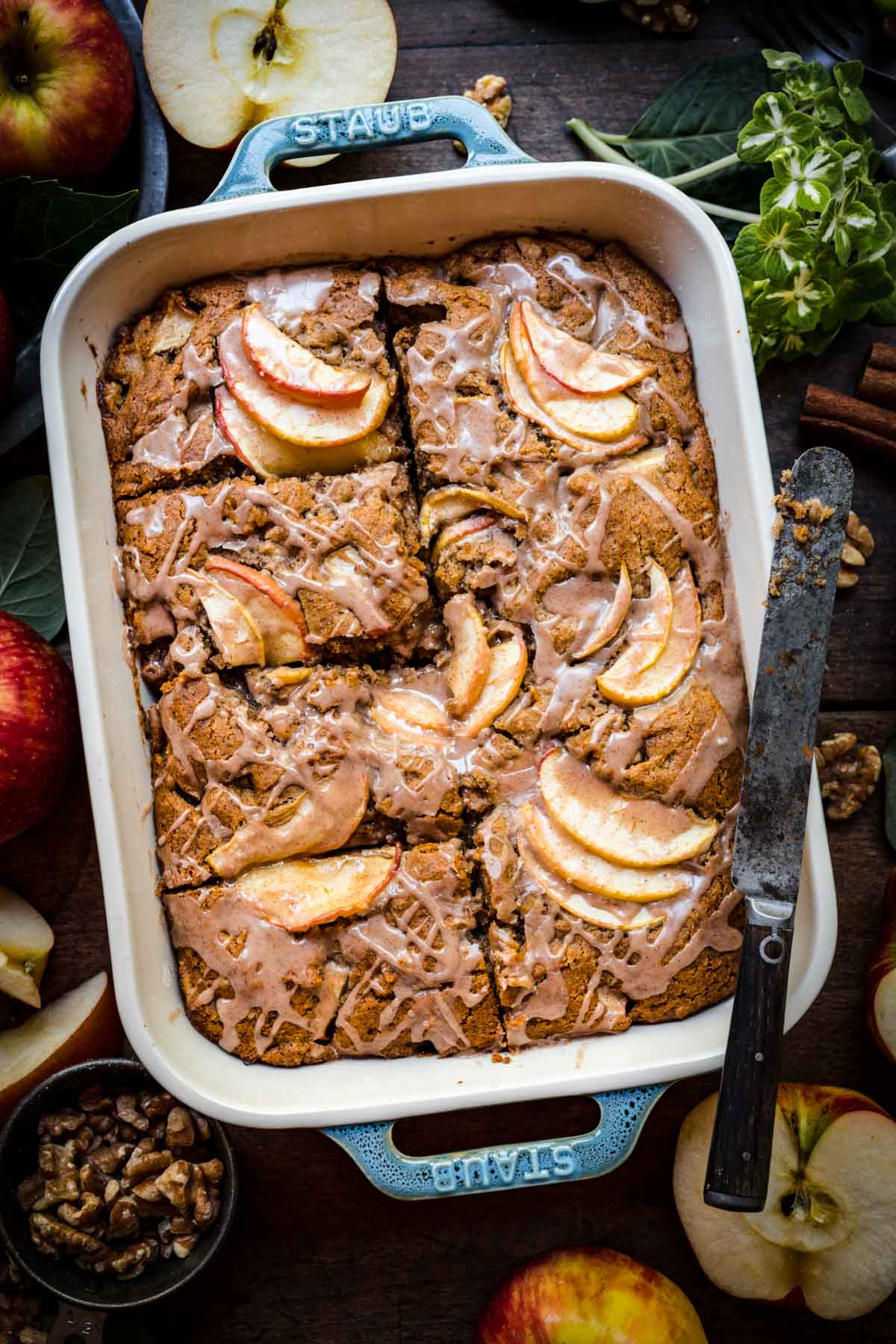 overhead view of vegan apple cake sliced in baking pan with cinnamon glaze. 