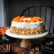 Front view of carrot cake on a cake stand.