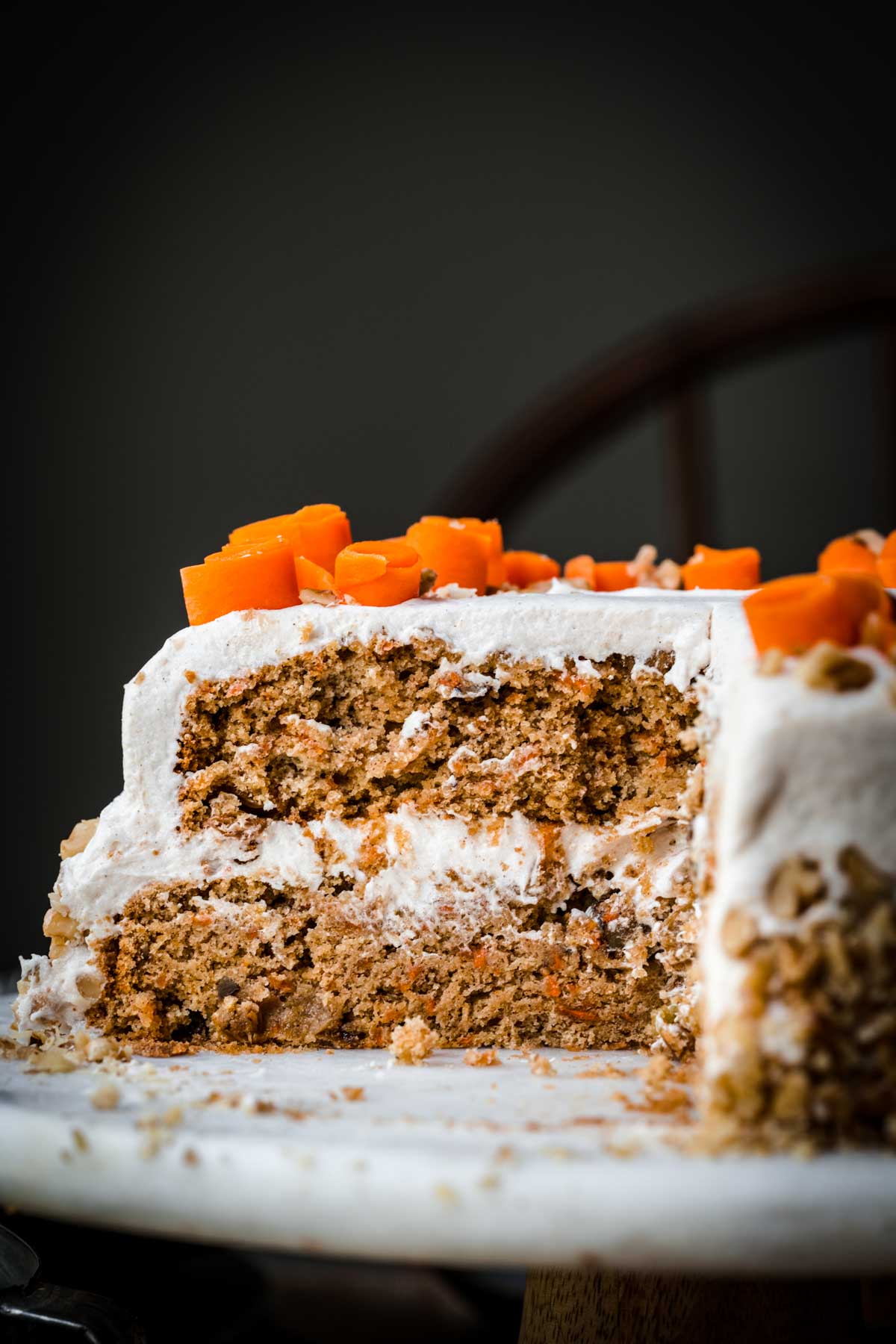 side view of vegan carrot cake slice on cake stand. 