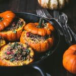 Side view of Stuffed Mini Pumpkins with Wild Rice and Mushrooms in a cast iron skillet