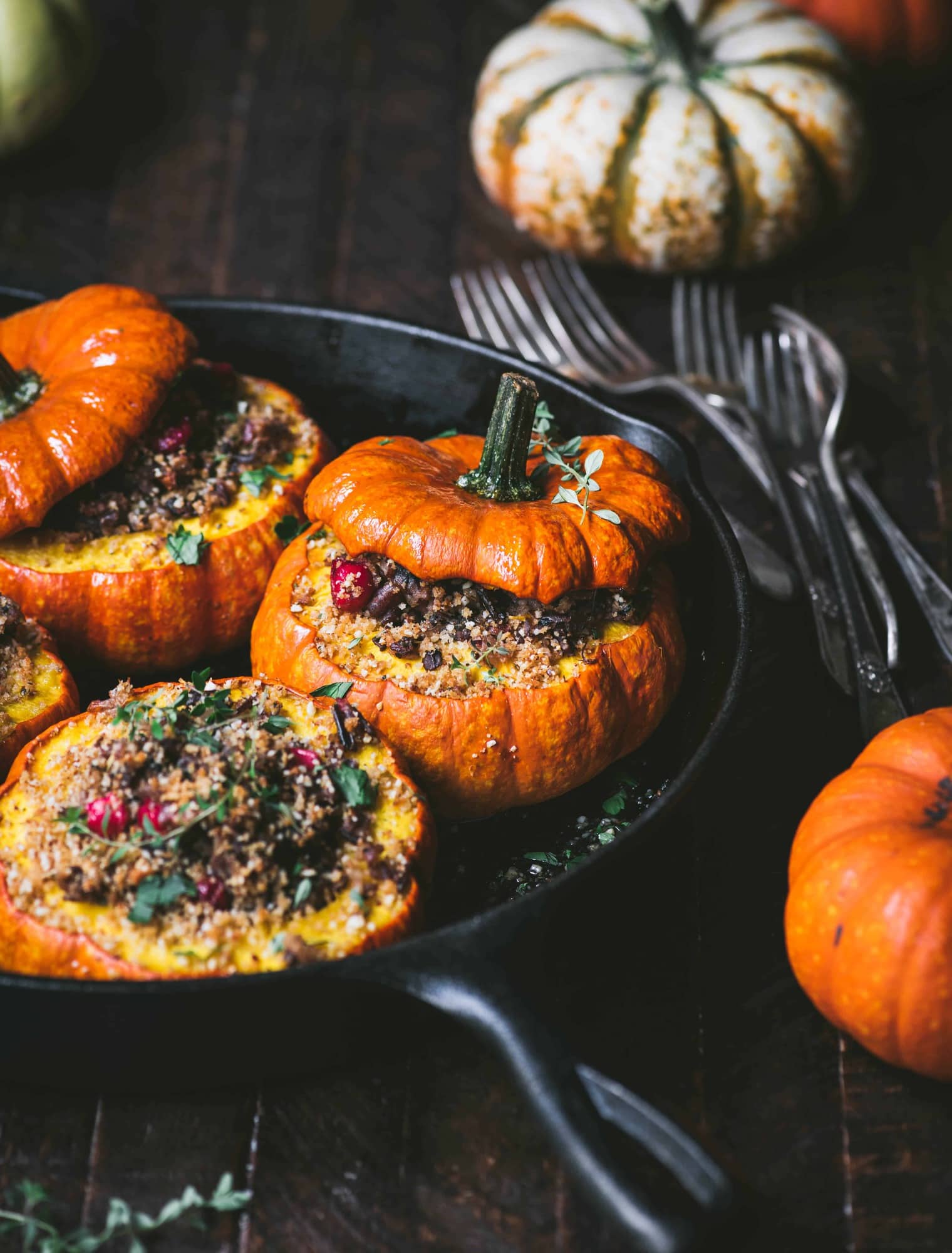Side view of Stuffed Mini Pumpkins with Wild Rice and Mushrooms in a cast iron skillet