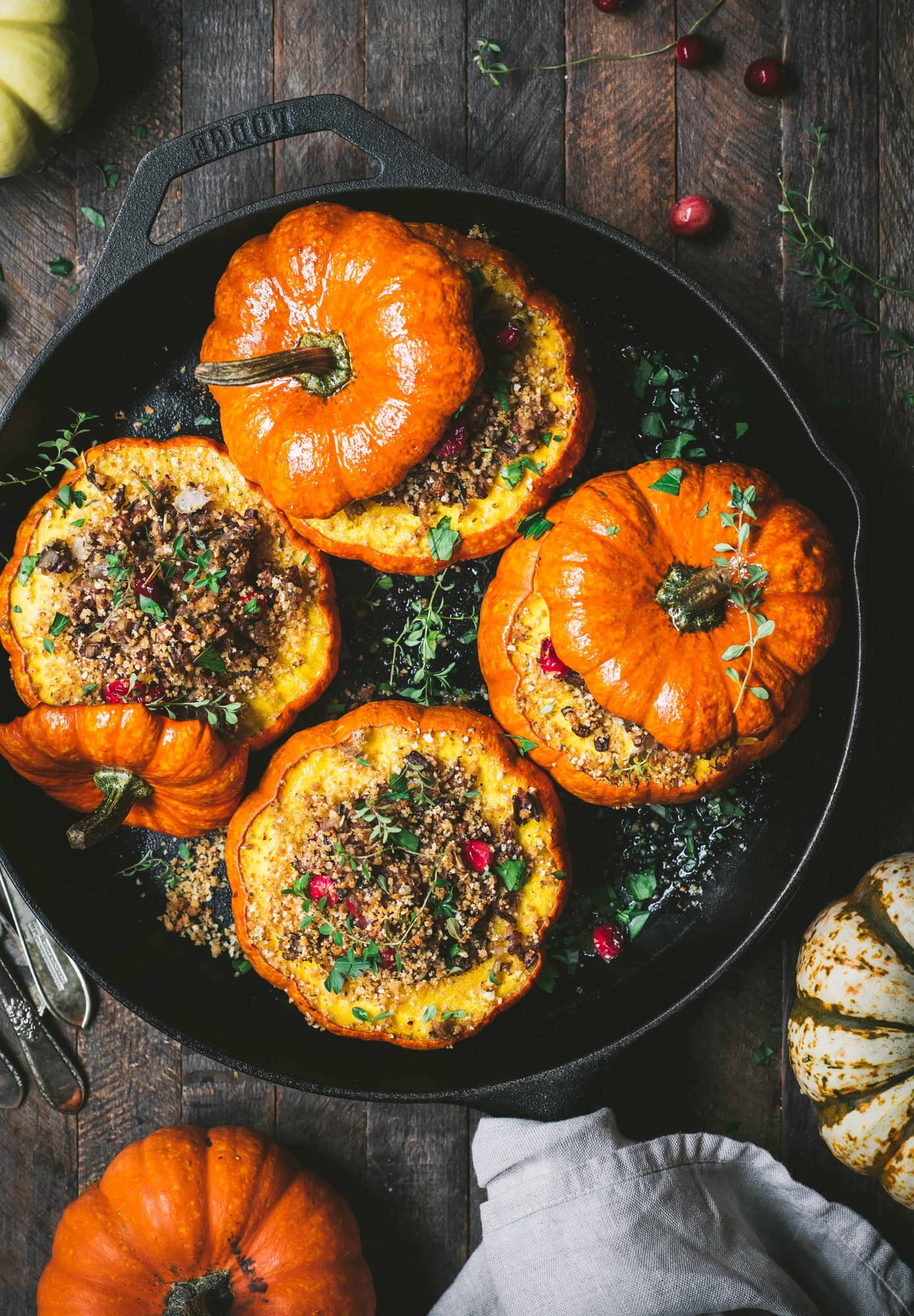 Overhead view of 4 Stuffed Mini Pumpkins with Wild Rice and Mushrooms in a cast iron skillet