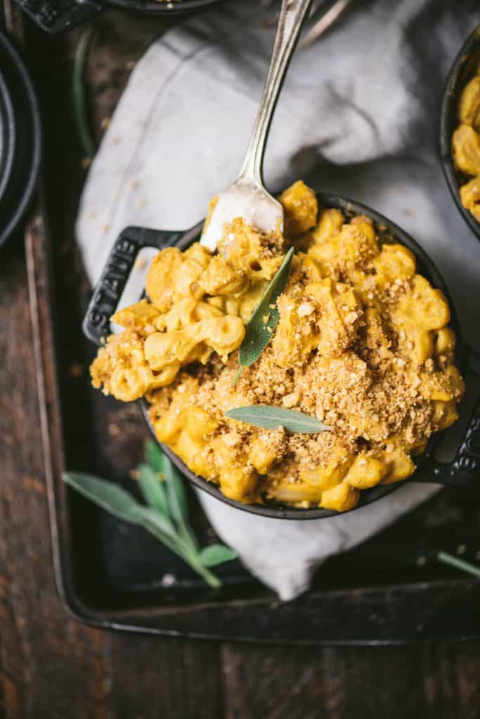 Close up overhead of vegan pumpkin mac and cheese in a mini Staub black cast iron coquette