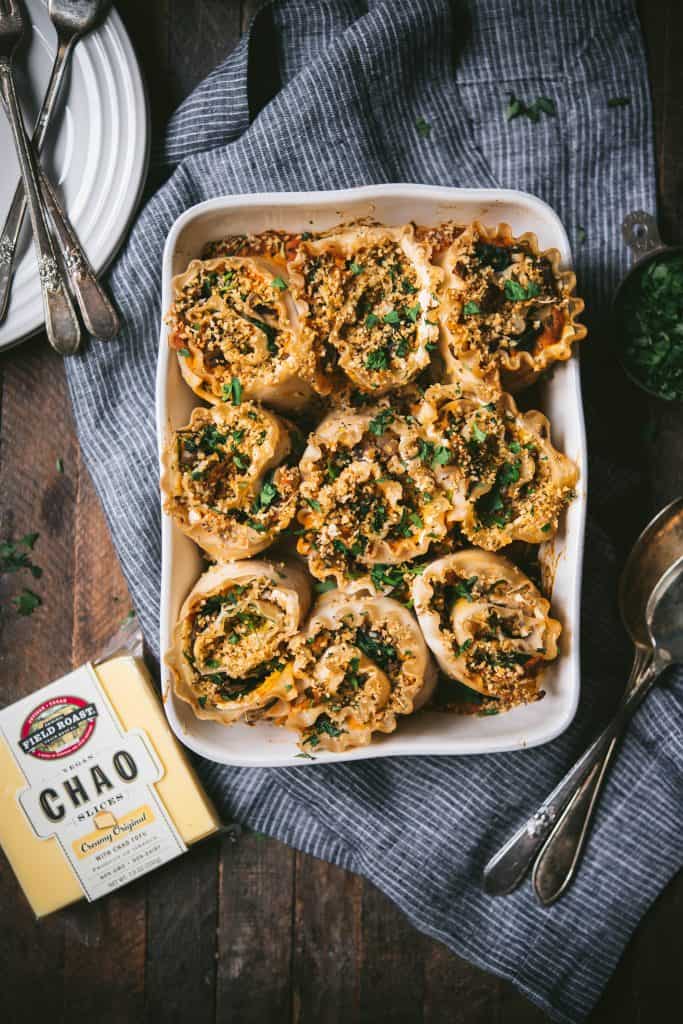 Overhead of vegan butternut squash lasagna roll ups in a white pan with Chao vegan cheese