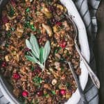 Close up of gluten free stuffing with fresh sage in an oval baking pan with two spoons