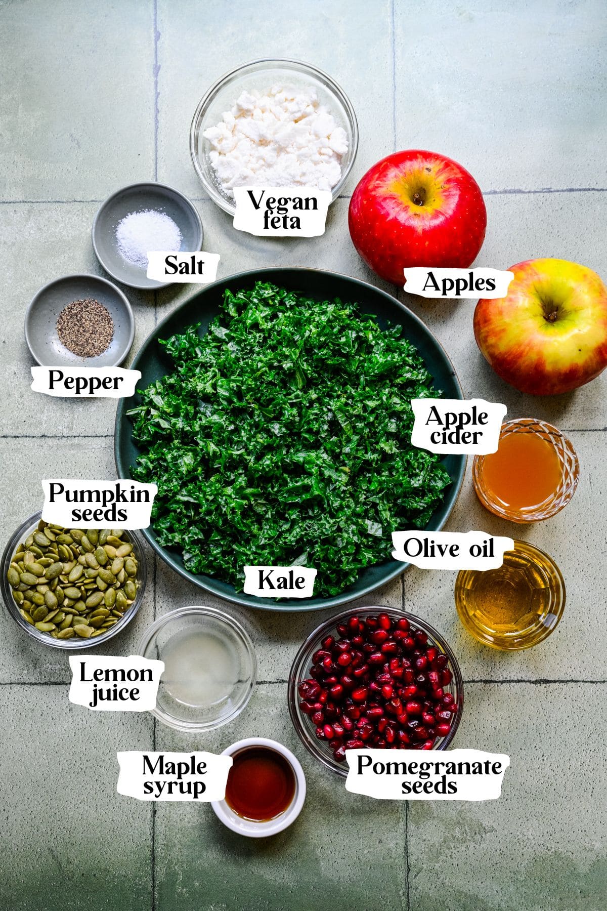 Kale apple salad ingredients including apples, pomegranate seeds and kale.