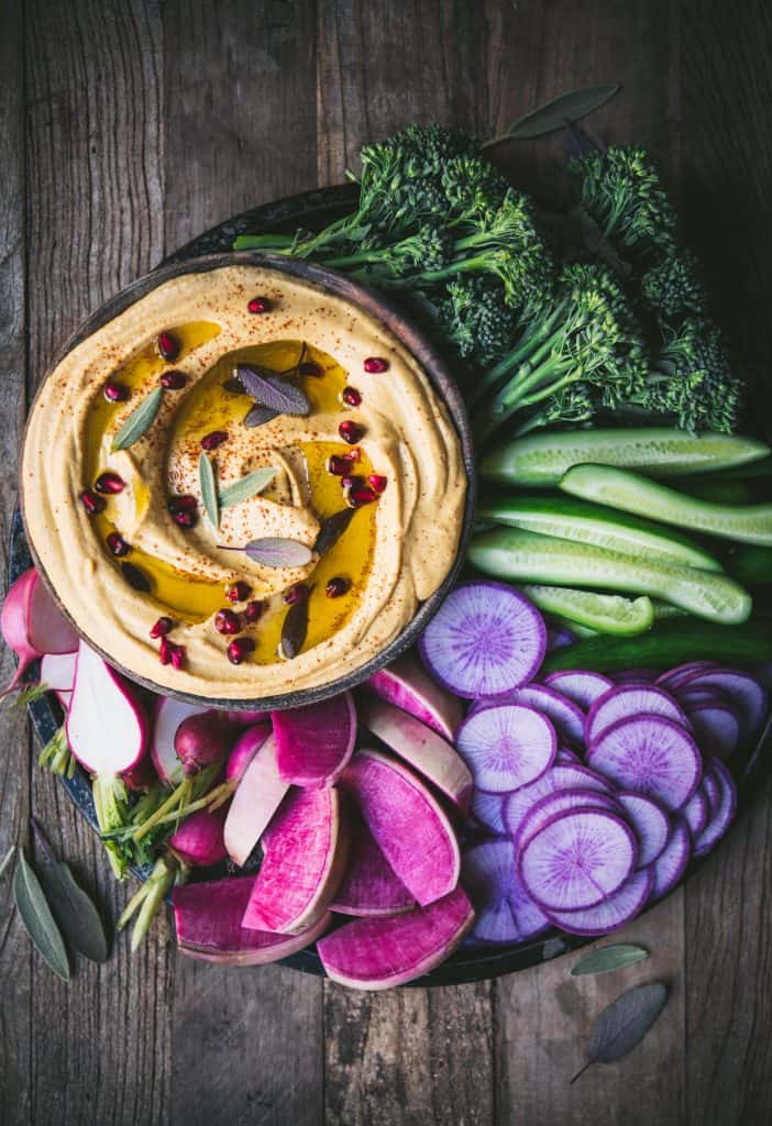Colorful vegetable platter with bowl of creamy pumpkin hummus