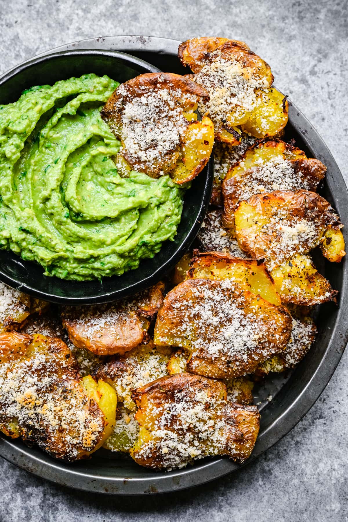 Finished potatoes in a tin with dipping sauce.