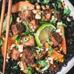 Close up of black rice with veggies and five spice tofu in a bowl with chopsticks