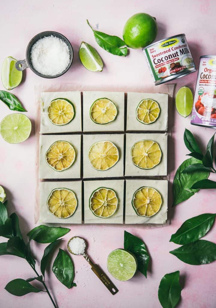 Overhead of coconut lime cheesecake bars on a pink background