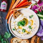 Overhead of White Bean Dip with toasted bread and colorful vegetables