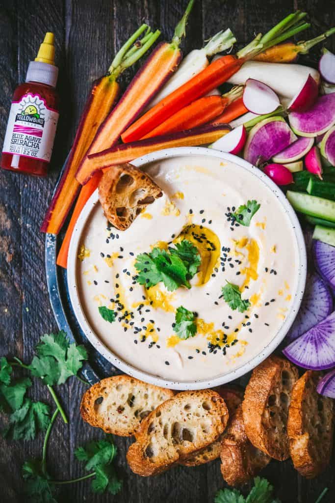 Overhead of White Bean Dip with toasted bread and colorful vegetables