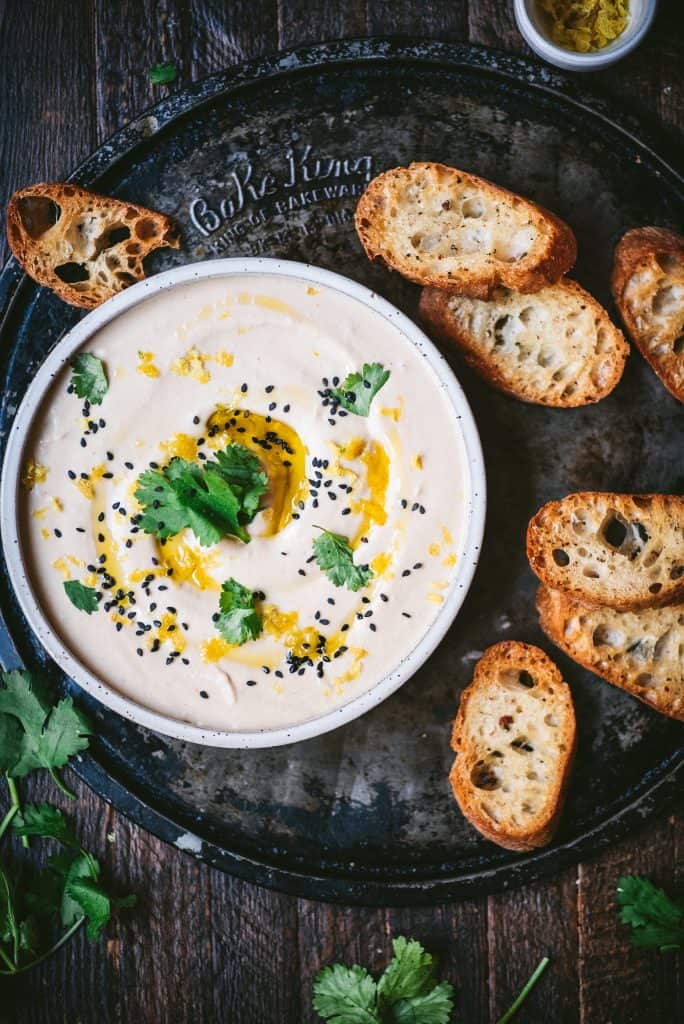 Overhead of White Bean Dip with toasted bread on vintage background