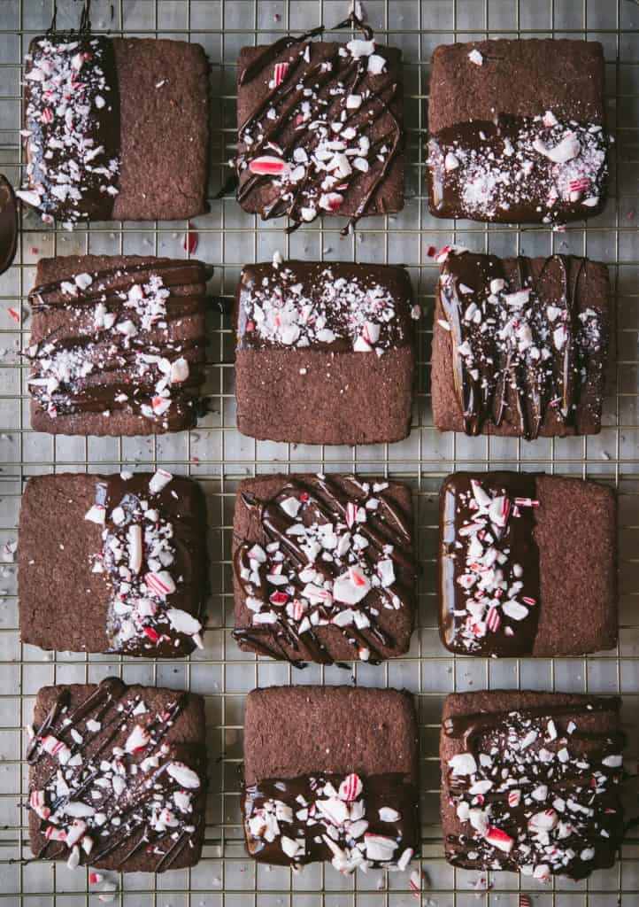 Overhead of chocolate dipped peppermint shortbread cookies on a cooling rack