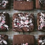 45 degree angle of chocolate dipped shortbread cookies with crushed peppermint on a cooling rack