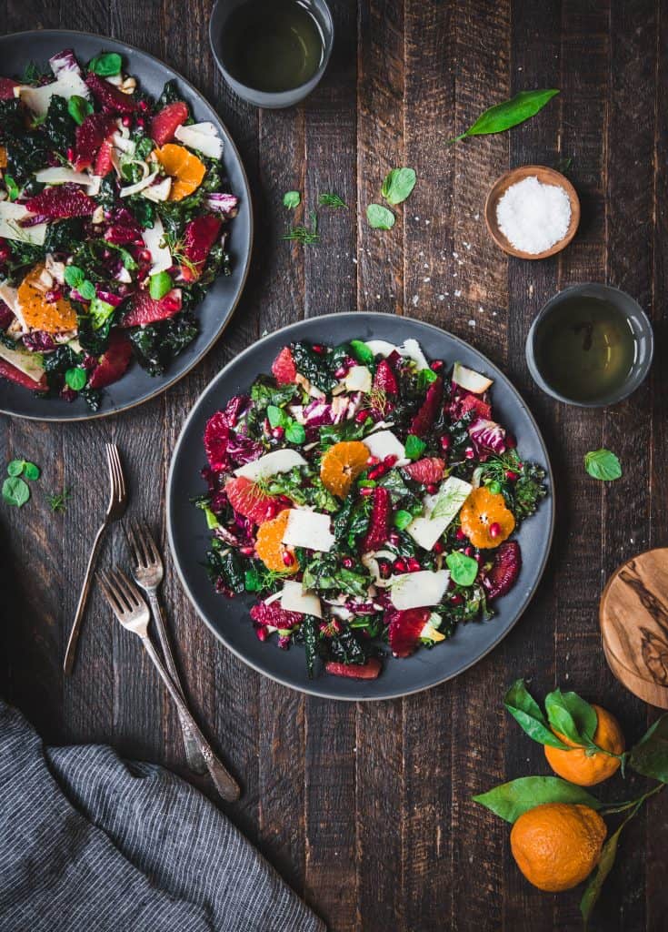 Overhead shot of beautiful winter greens and citrus salad on rustic wood background