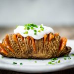 Side view close up of vegan cheesy hasselback potato